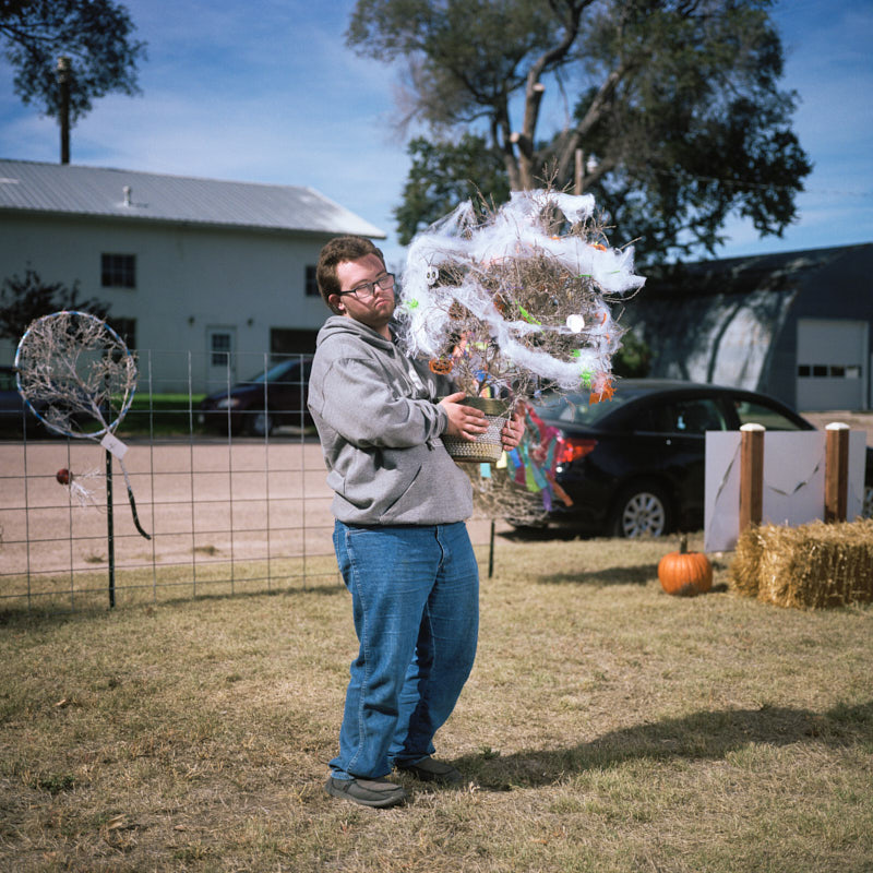 A boy holding a spooky decorated tumbleweed