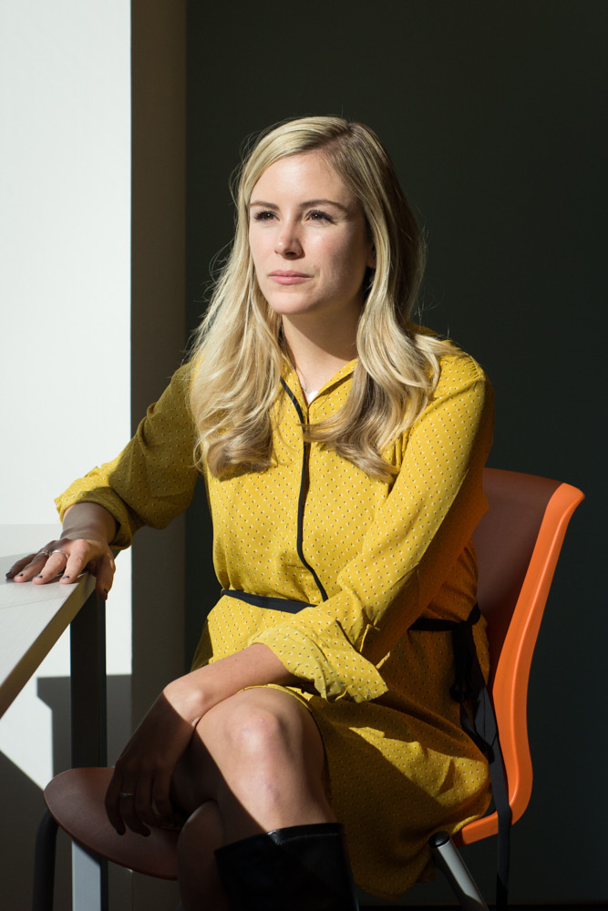 A businesswoman sitting by a sunlit window in her office