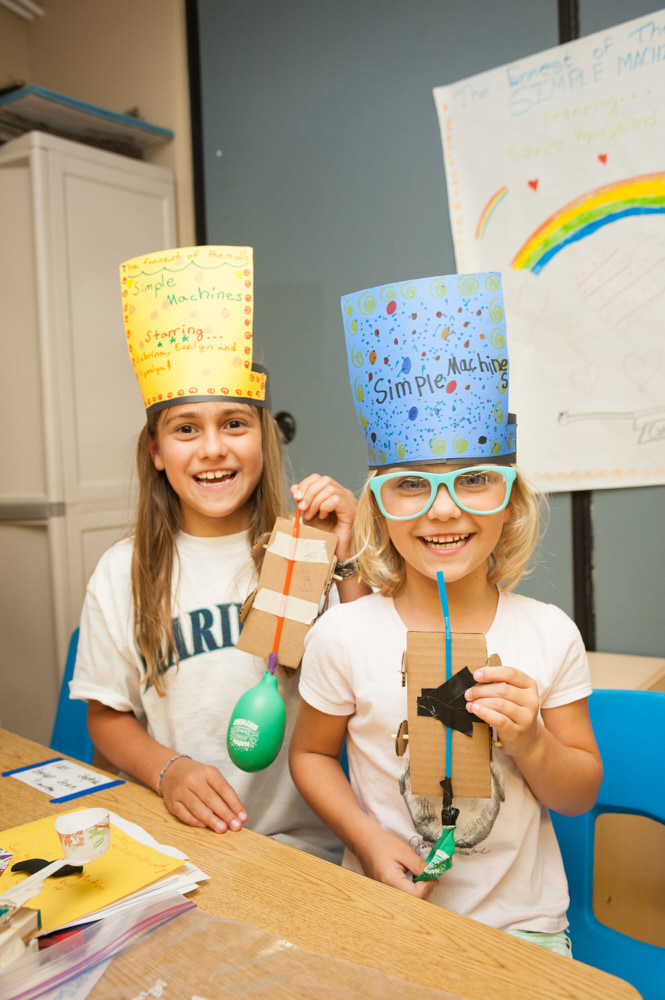 Two campers hold balloon rockets that they made