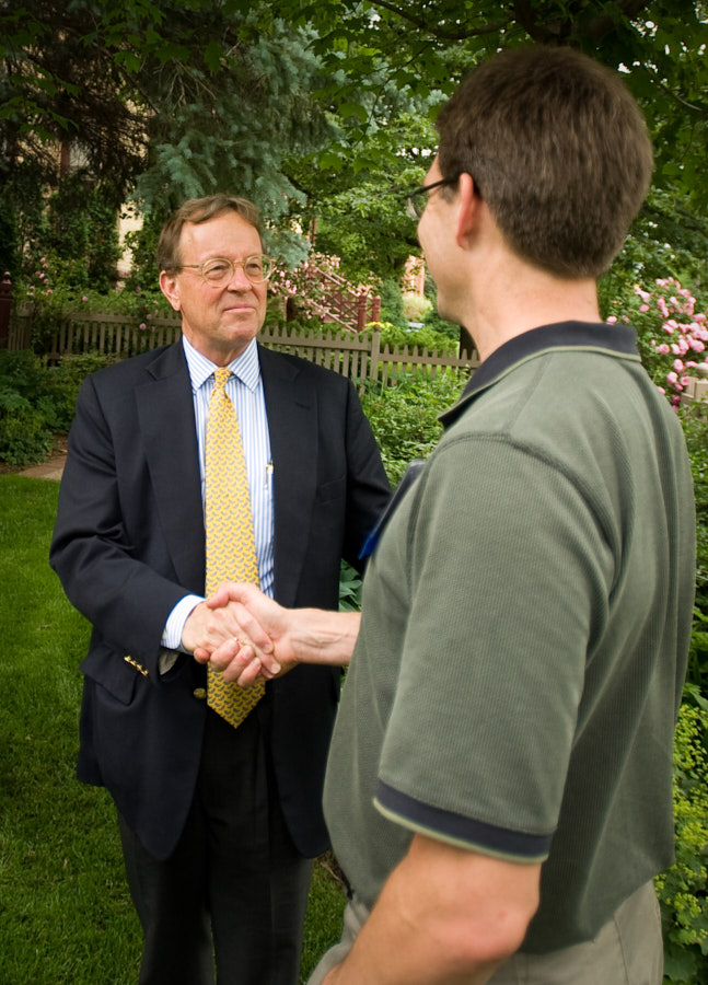 A college president shakes hands with an alumnus