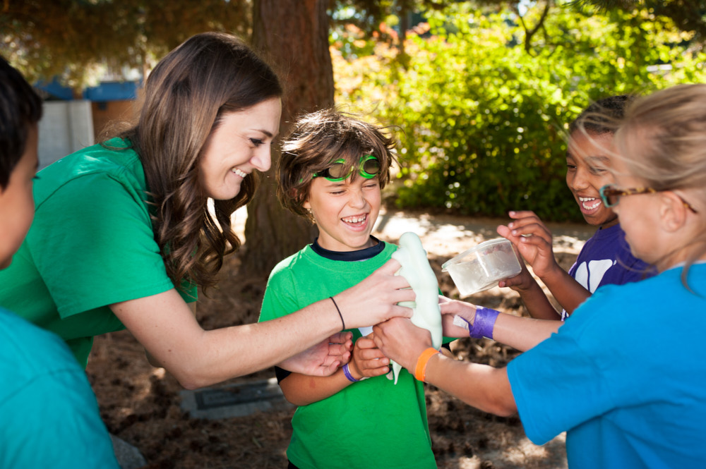 A counselor creates a fizzy science experiment with four campers
