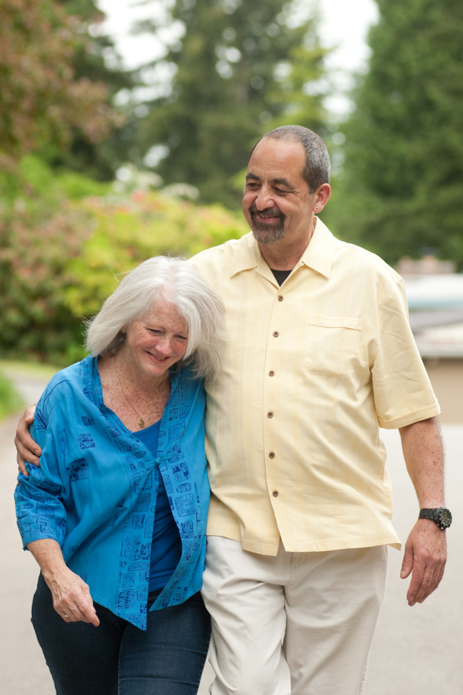 An elderly couple walking while embracing