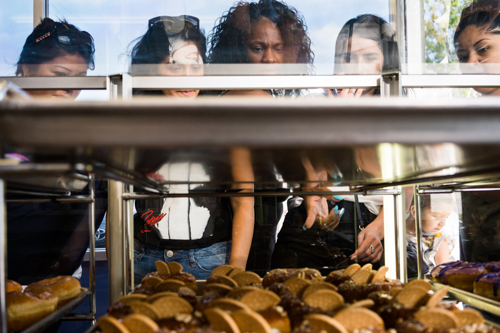 Customers looking at donuts in a glass case