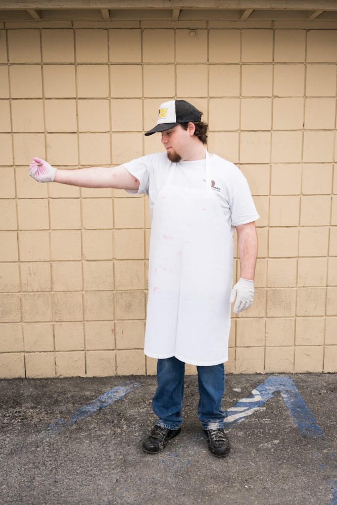 A portrait of a donut baker showing oil burns on his arms