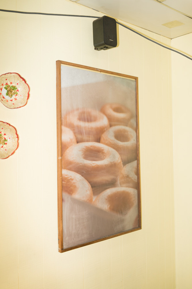 A picture of donuts hanging on a yellow wall