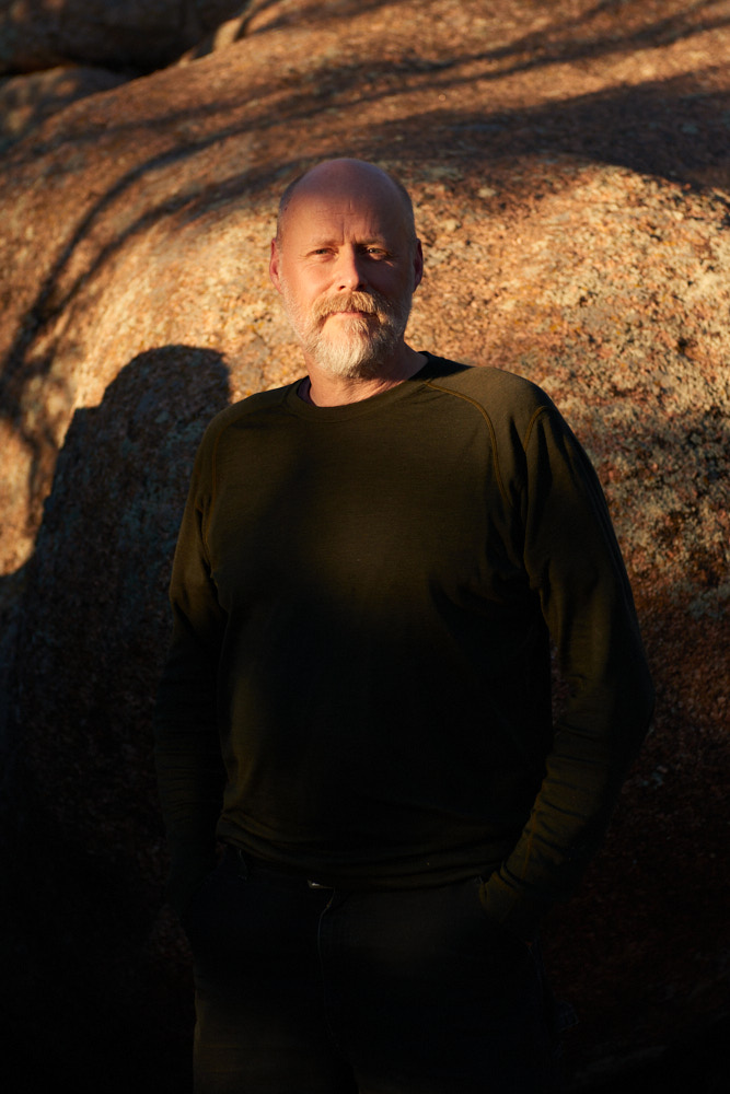 A portrait of Jason Shogren at sunset in front of rocks