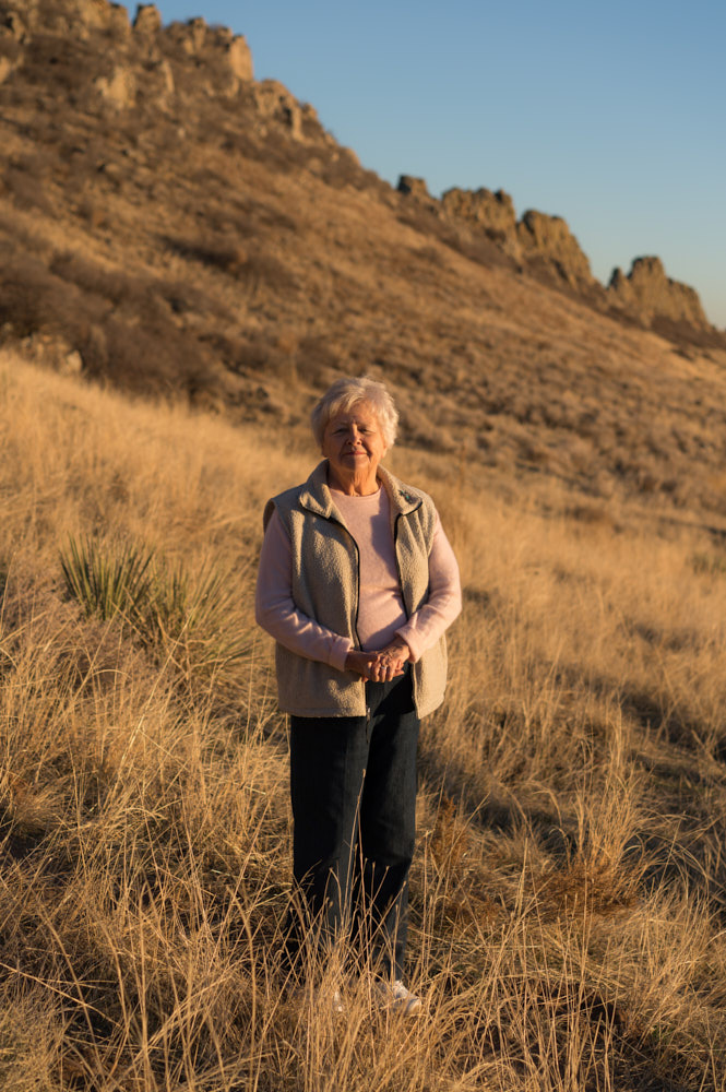A portrait of an elderly woman in the mountains at sunset