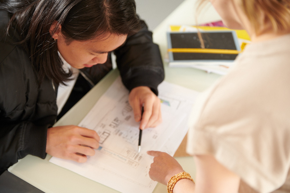 employees-collaborating-at-desk-with-pencil