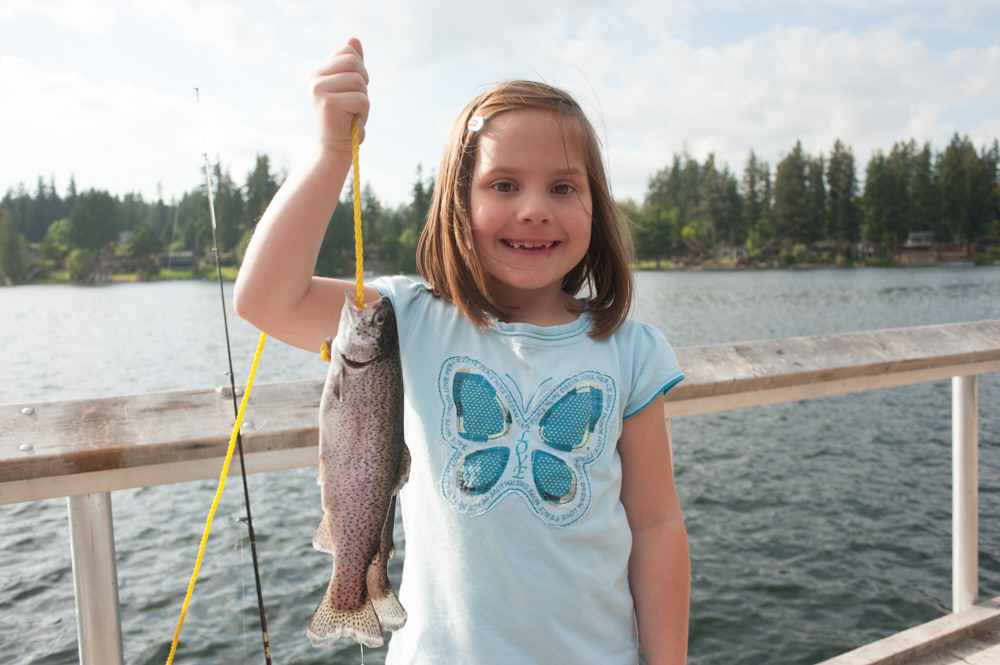 A portrait of a girl holding a fish she just caught