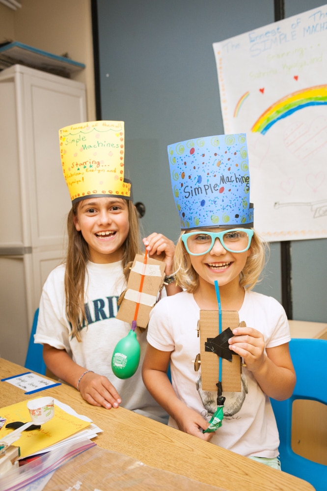 Two girls holding cardboard balloon science projects