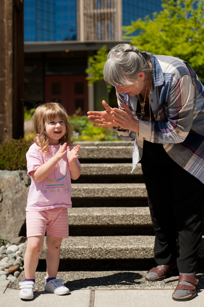 A grandmother and granddaughter smiling and clapping together