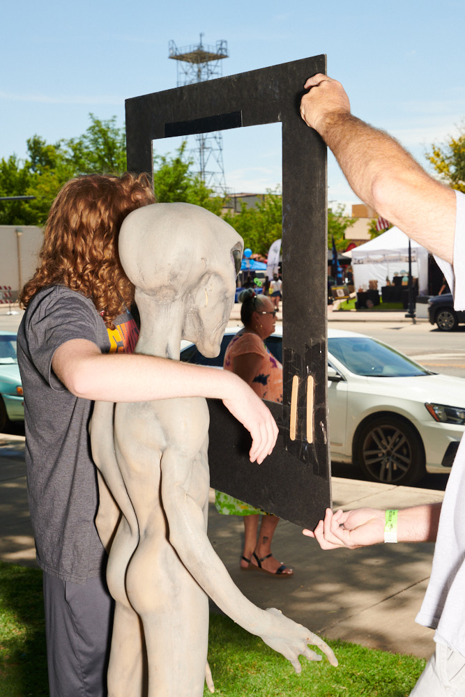 A boy posing with an alien for a photograph