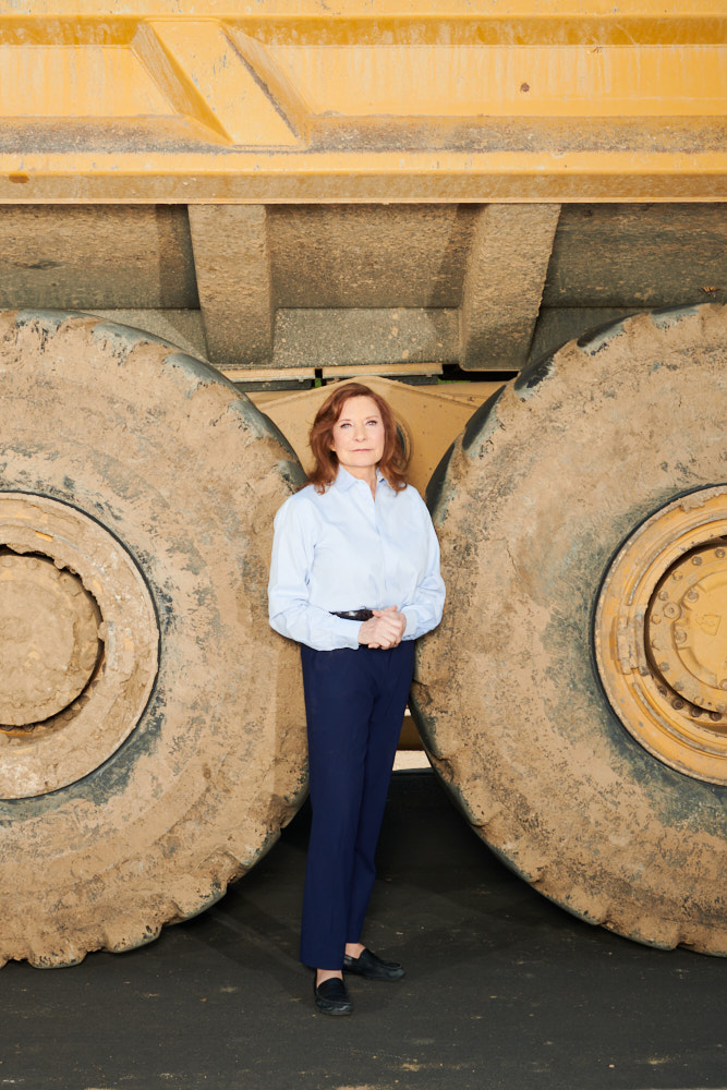 A portrait of Linda Alvarado in front of a large construction vehicle