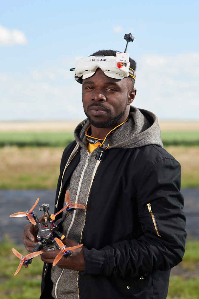 A portrait of a man holding a drone wearing a headset