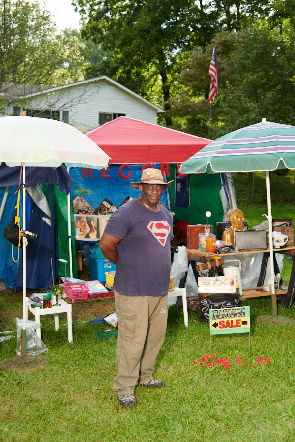 A portrait of a man selling records and collectibles