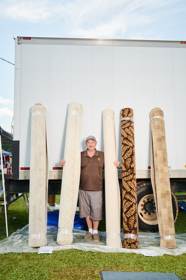A portrait of a man selling large rugs