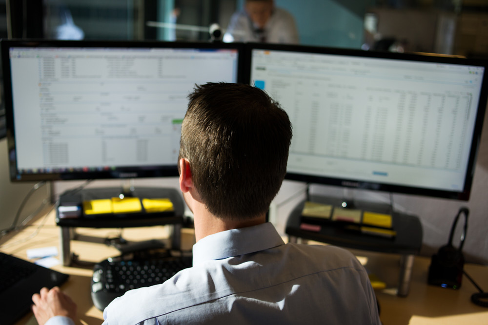 A man viewed from behind working at his computer