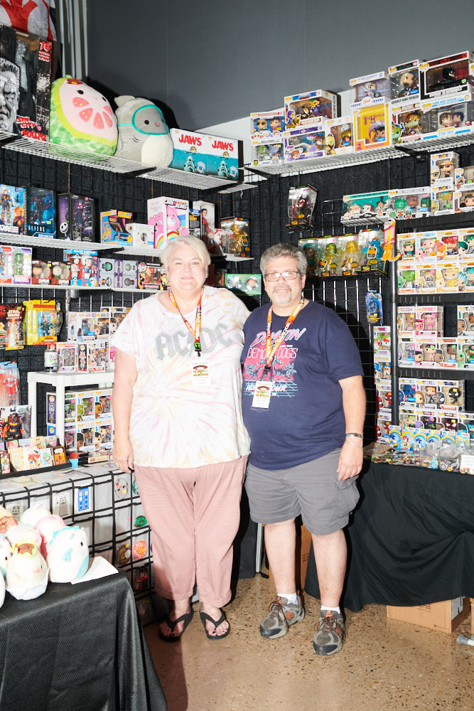 Two people posing for a portrait in a collectibles booth