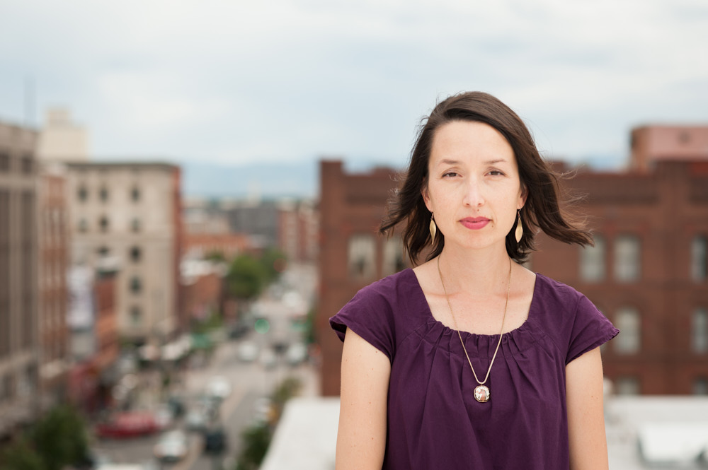 A businesswoman poses for a portrait on a rooftop