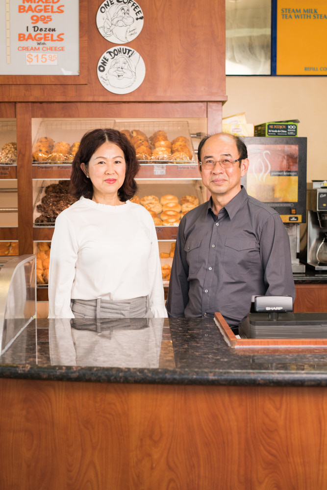 A portrait of Jenny and Bruce Bu in their donut shop