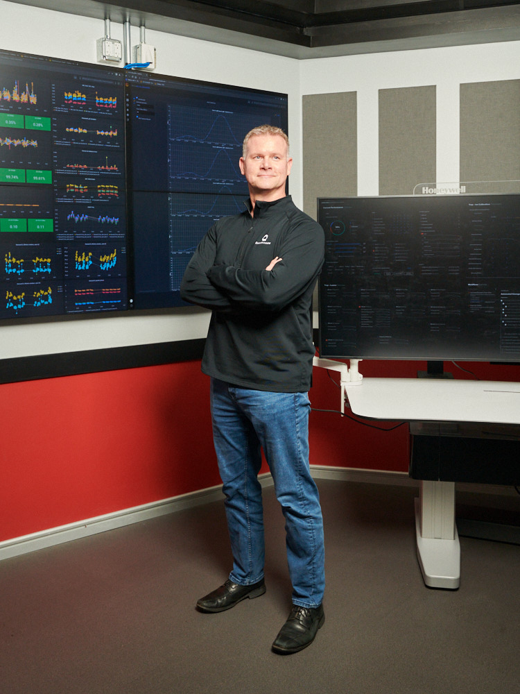 Quantinuum CEO Tony Uttley posing for a portrait in front of computer screens