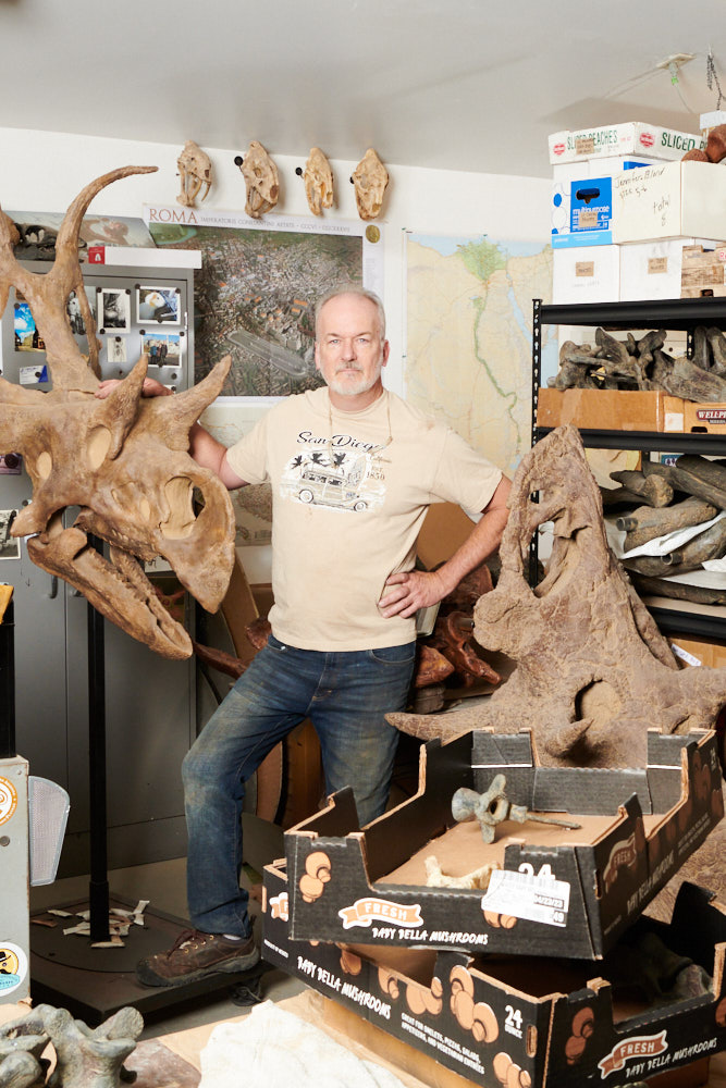 A portrait of Rob Gaston with his fossil replicas (vertical)