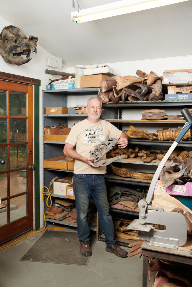 A portrait of Rob Gaston holding a fossil replica skull