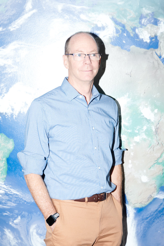 A portrait of a scientist in front of a painted wall at NCAR