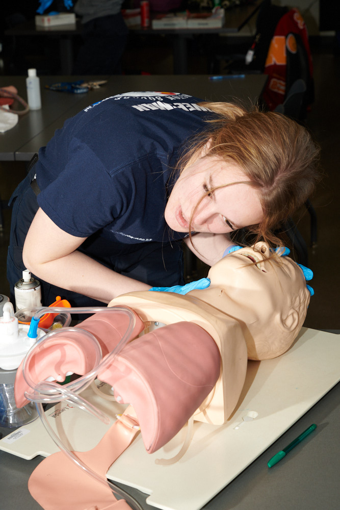 A student practices CPR with a dummy
