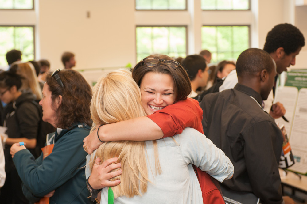Two students hug during a conference