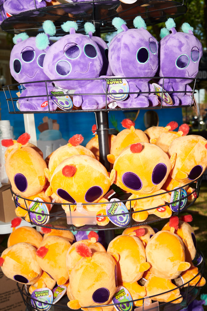 Purple and orange alien stuffed animals on a rack