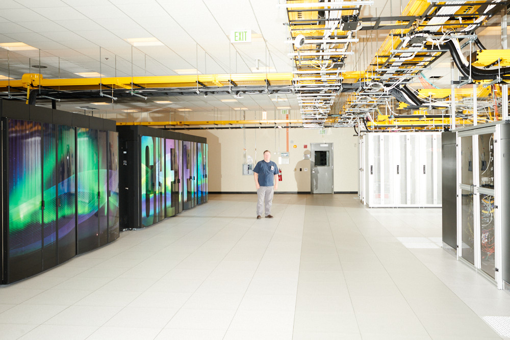 A technician standing inside the Cheyenne supercomputer
