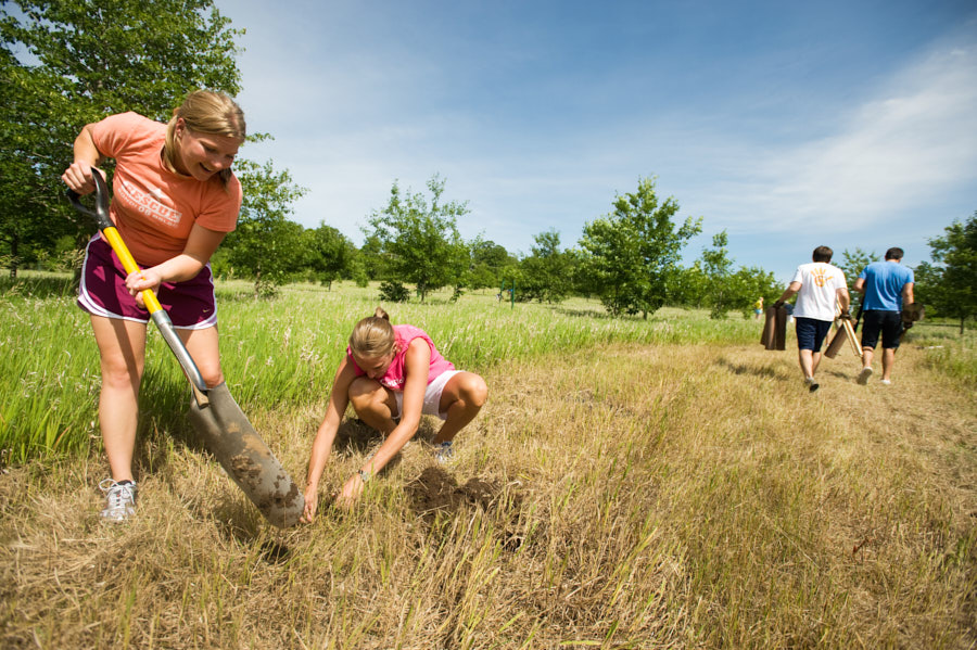 Two students dig during an outdoor service project