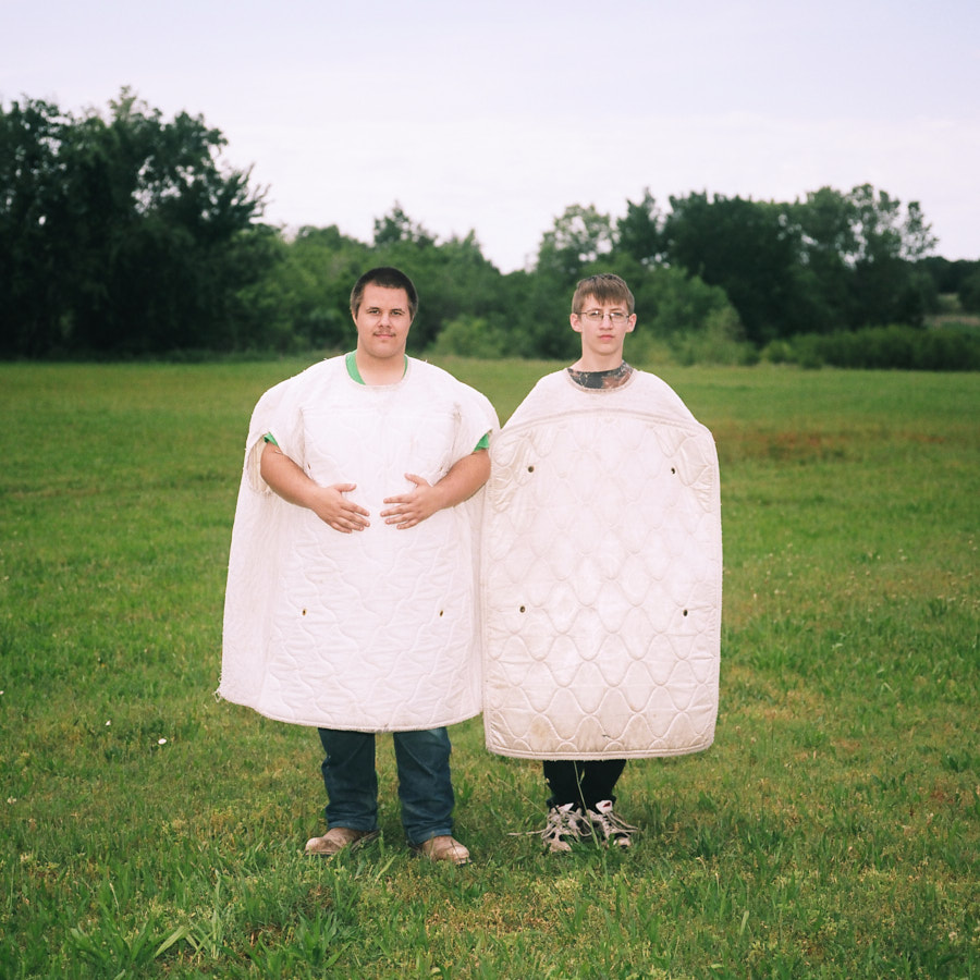 A portrait of two young men wearing mattress costumes