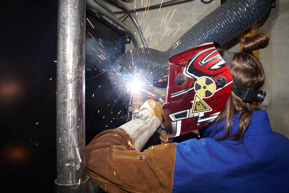 A welding student using a torch