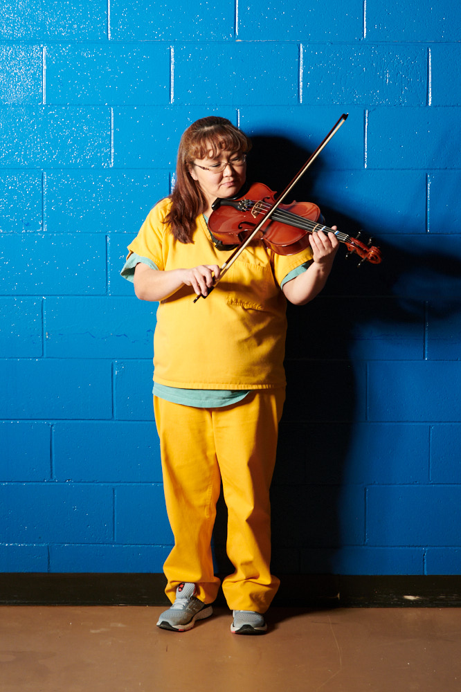 A portrait of an incarcerated woman playing a violin