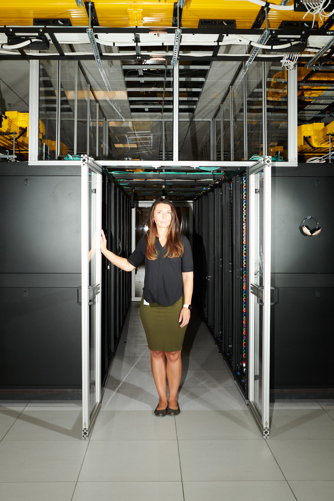 Portrait of a woman in front of a server cluster inside the Cheyenne supercomputer