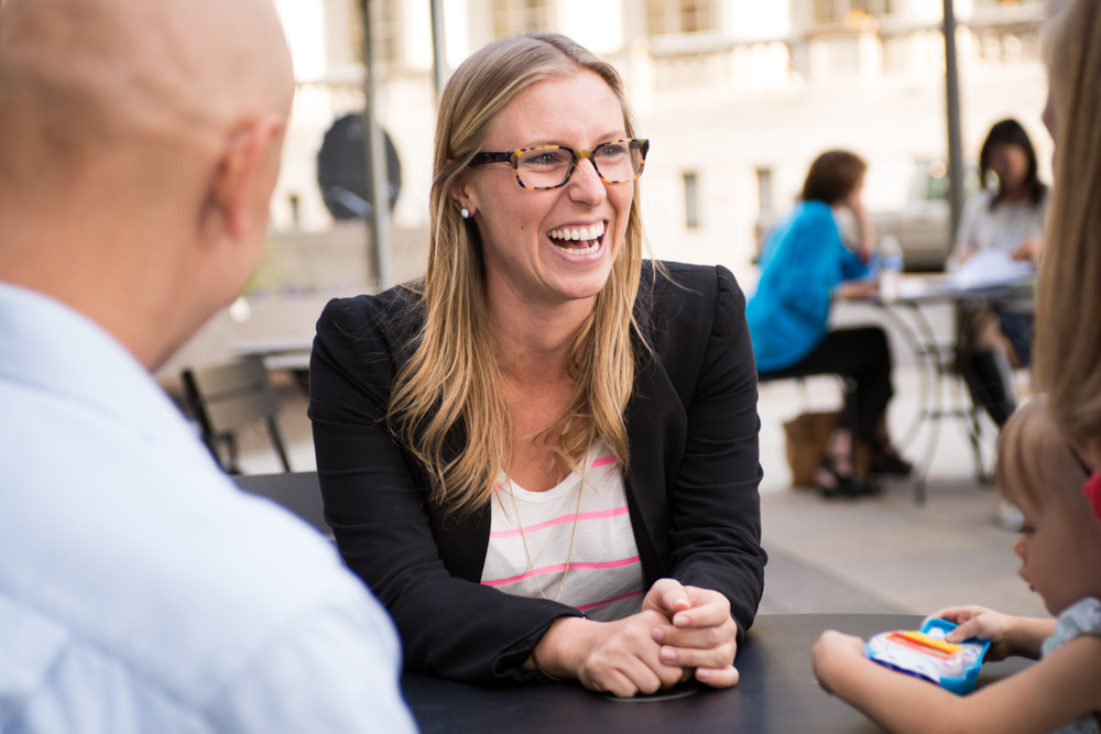 A businesswoman smiles while meeting with a family