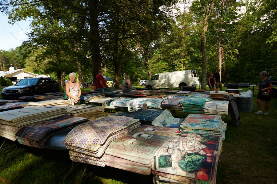 Women examining rugs and mats for sale