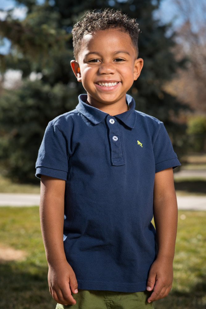 A young student smiles outside for a portrait