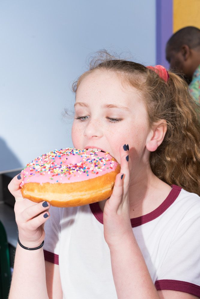 A girl eating an enormous donut