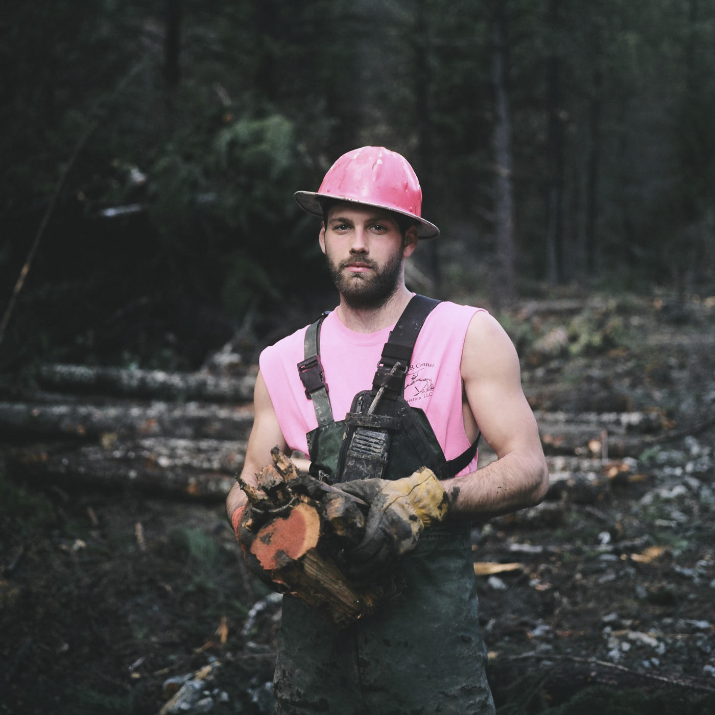01-logger-wearing-pink-holding-wood-portrait