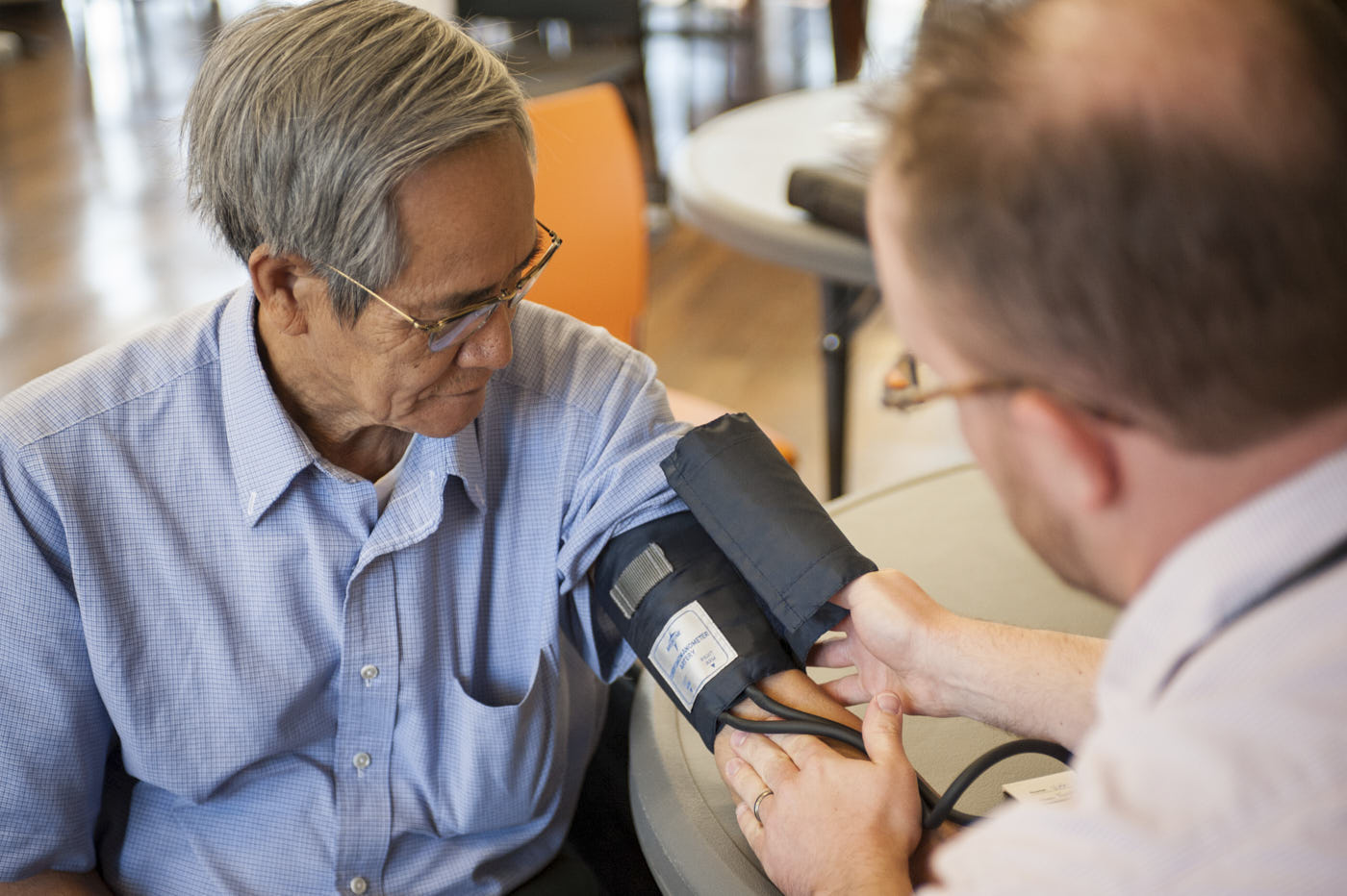 A man receiving a medical checkup with a blood pressure cuff