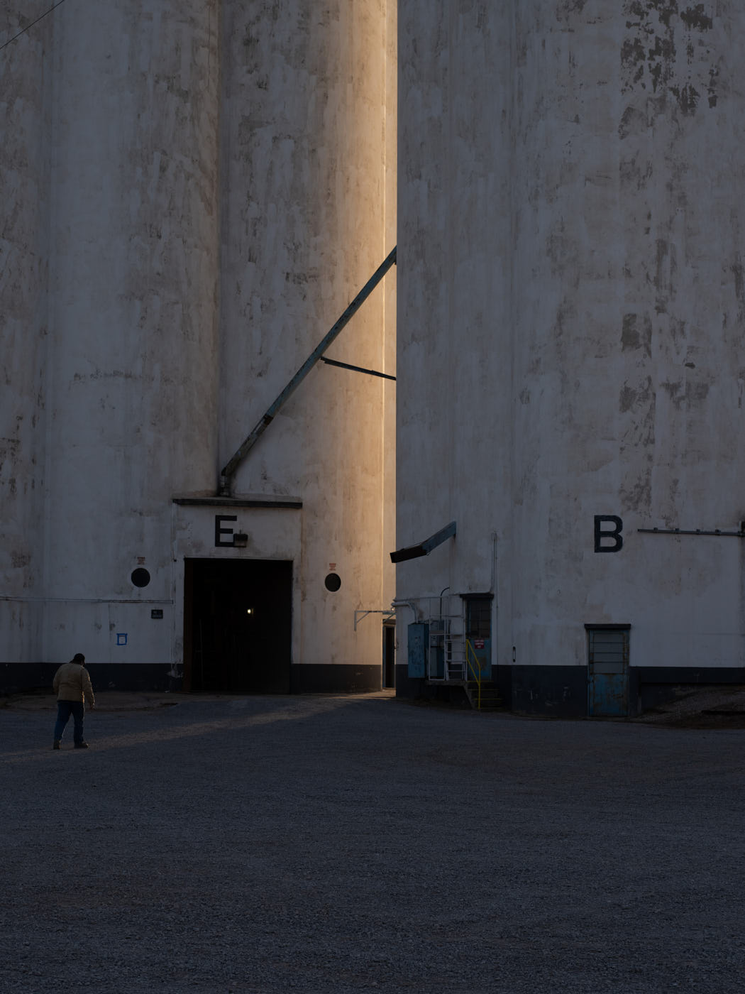 01-man-walks-near-grain-silos
